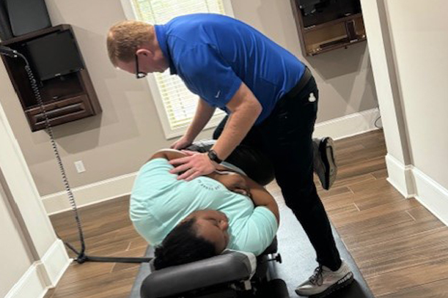Dr. Blake Derrick giving female patient a hip pain treatment